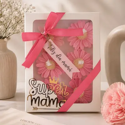 Caja blanca con ventana y seis velas con forma de margarita rosada, lazo fucsia y aplique dorado Súper Mamá