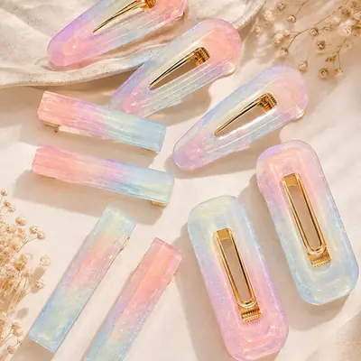 Nueve ganchos para el cabello en resina con degradados pastel y herrajes dorados, en varias formas