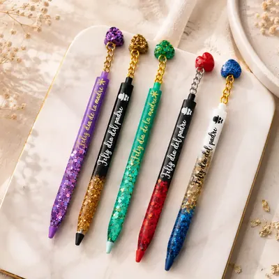 Cinco lapiceros de resina con glitter de colores y frases para el Día de la Madre y del Padre, con dijes de corazón