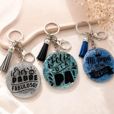 Tres llaveros redondos de resina con glitter plateado, turquesa y azul, con frases para el Día del Padre