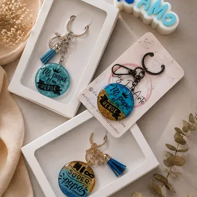 Tres llaveros redondos de resina con frases para papá, en azul turquesa y dorado, dos en caja de regalo