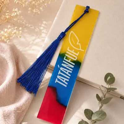 Marca páginas de resina con los colores de la bandera de Colombia, el nombre de una institución y borla azul