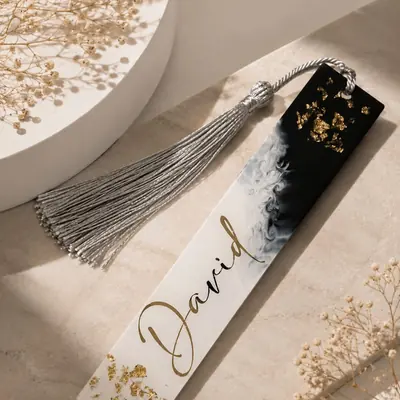 Marca páginas de resina con mármol blanco y negro, hoja de oro y el nombre en dorado, con borla plateada