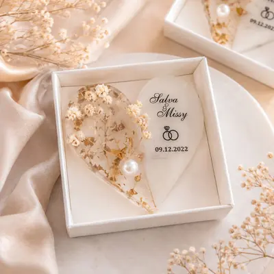 Recordatorio de matrimonio: corazón de resina con flores naturales, hoja de oro, perla y los nombres impresos, en caja blanca
