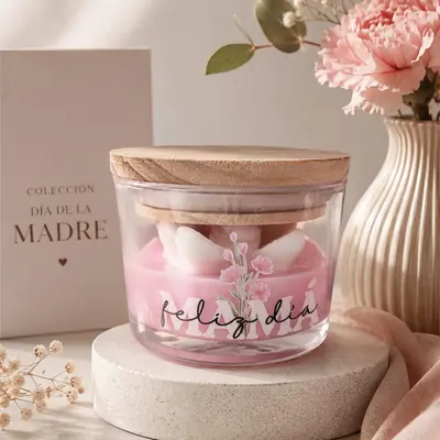 Vela rosada en frasco de vidrio con tapa de madera, corazones de cera blancos y etiqueta Feliz día Mamá