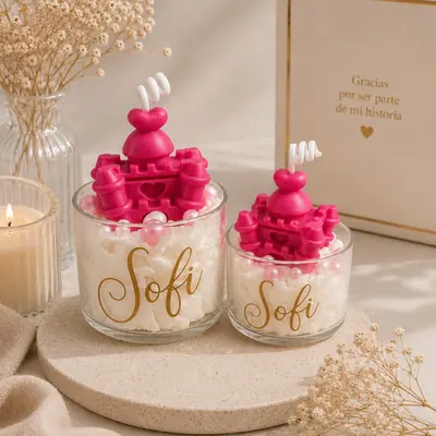 Velas en vaso de policarbonato con crema de cera, perlas rosadas y un castillo fucsia, con el nombre Sofi en dorado